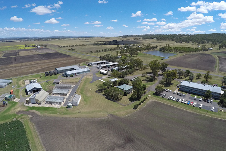 Aerial photograph of the Hermitage Research Facility, showing agricultural buildings, farming land, dam and vehicles.