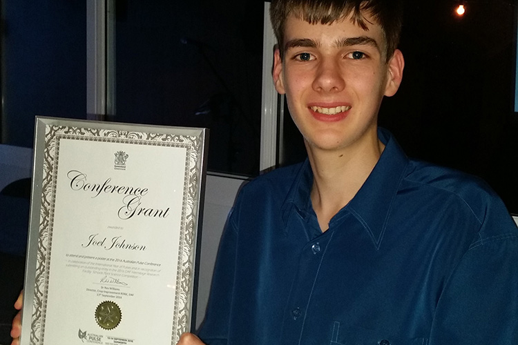 High school student holding framed Conference Award certificate.